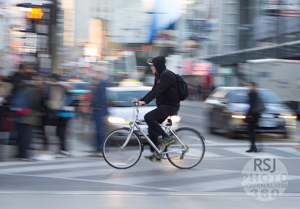 A man bikes down Dundas at the Yonge and Dundas intersection in downtown Toronto on November 9, 2015. Photo by  Augustine Ng