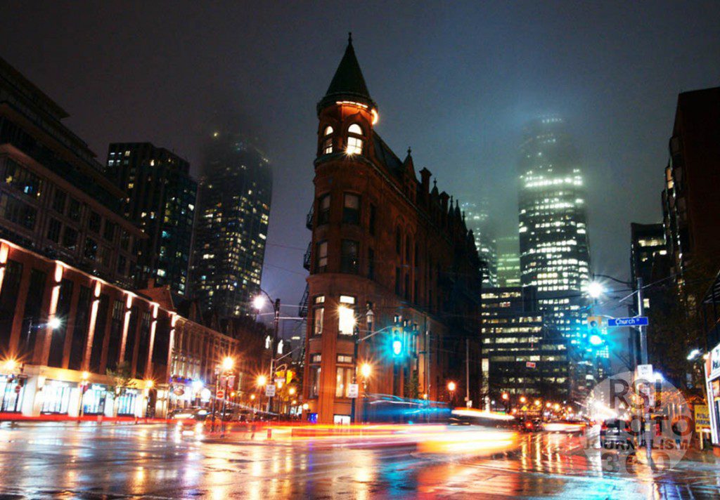 The  Gooderham Building in Toronto during a rainy night , Nov.10, 2015. Wet roads are reflecting traffic lights and lights of cars passing by.  Photo by Amanda Skrabucha