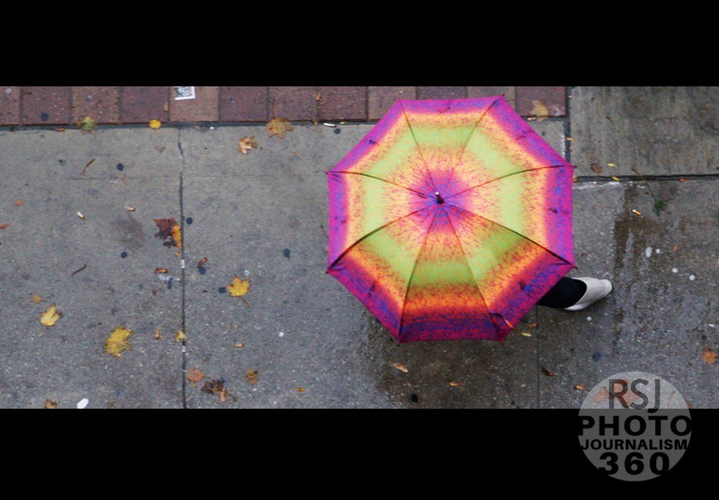 A birds' eye view of a women walking with her colourful umbrella on Church Street in Toronto during a windy and rainy day, Oct. 28, 2015.  Photo by Amanda Skrabucha